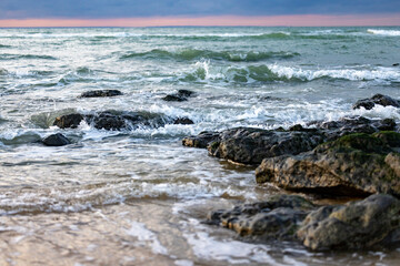 Sea waves hitting rocks on the beach with turquoise sea water causing water splashes. Amazing rock cliff seascape in the French opal coastline. . High quality photo
