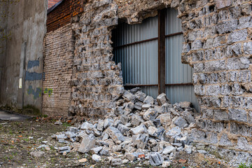 gap in the wall with bricks scattered under it