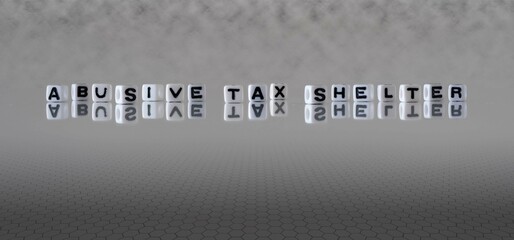 abusive tax shelter word or concept represented by black and white letter cubes on a grey horizon...