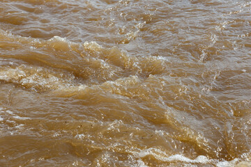 Muddy river water. Spring river with brown muddy water. Background
