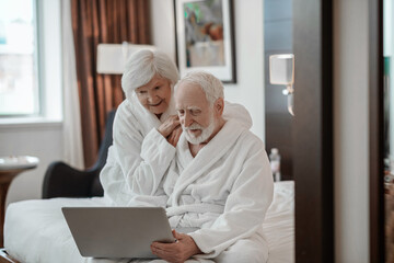 Elderly couple in a hotel room having good time