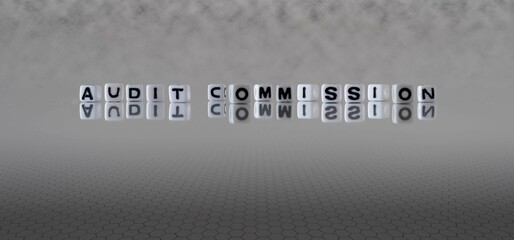 audit commission word or concept represented by black and white letter cubes on a grey horizon background stretching to infinity