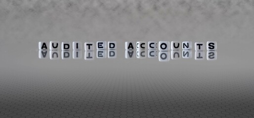 audited accounts word or concept represented by black and white letter cubes on a grey horizon background stretching to infinity