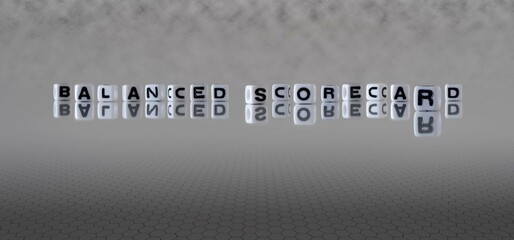 balanced scorecard word or concept represented by black and white letter cubes on a grey horizon background stretching to infinity