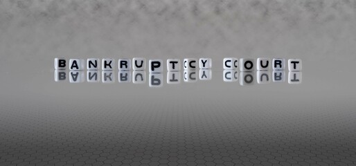bankruptcy court word or concept represented by black and white letter cubes on a grey horizon...