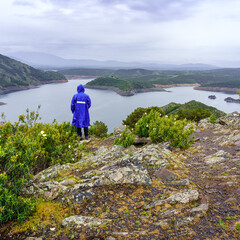 Fototapeta na wymiar Man contemplating the mountainous landscape on a rainy day.
