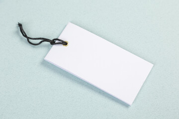 Empty white price tag on a gray-blue background with a soft shadow