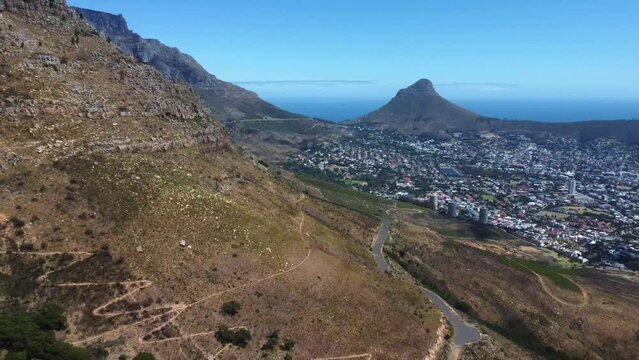 Drone shot of Cape Town - drone is reversing near Woodstock Cave at Table Mountain, facing Lions Head. Snippet could ideally be used for travel related videos or Cape Town movies.