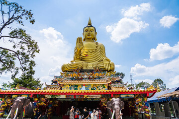 Fototapeta premium Nakhon Nayok, Thailand - April, 24, 2022 : Golden buddha statue of Maniwong Temple at Nakhon Nayok, Thailand.