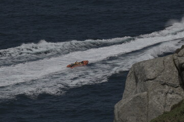 sea rescue boat motoring past rocks