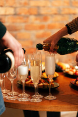 in the restaurant on the table there are glasses in which champagne is poured with warm lighting