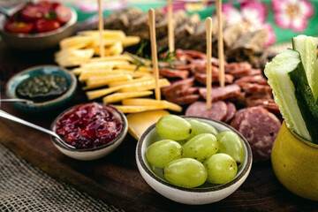 cold cuts, snacks and garnish, with artisanal Parmesan cheese, fresh tomatoes, German black bread, jam, pesto sauce, cucumbers, green grapes and vegetables