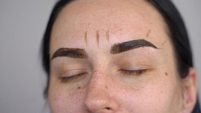 close-up applied henna on the eyebrows. markings are applied on the forehead to build the correct shape when staining