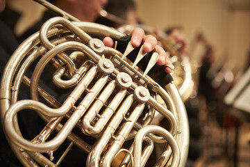 Close-up of a hand playing the horn at a concert - obrazy, fototapety, plakaty