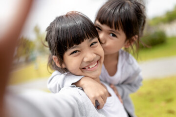Happy Asian child takes a selfie in the park.