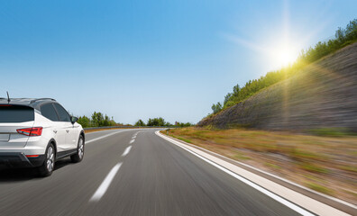 White car on the road. The car is driving along the highway.