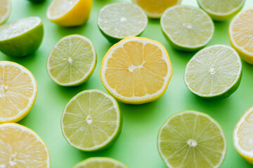 Fototapeta na wymiar Close up view of cut and juicy citrus fruits on green background
