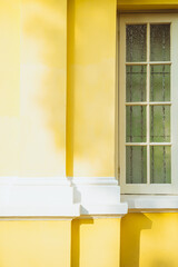 window in a yellow wall