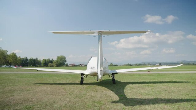 Fast expensive four-seat airplane parked on grass airport runway 4K
