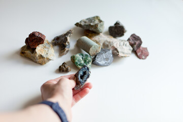 hand holding mineral stone resource. Woman holding pyrite, amethyst and labradorite gemstones, close
