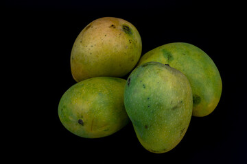 Mangoes isolated in white background, shot using studio lighting and water drops on the subject, Composition on a wooden log with extendable white background and ample copy space, Alphonso  Badami.