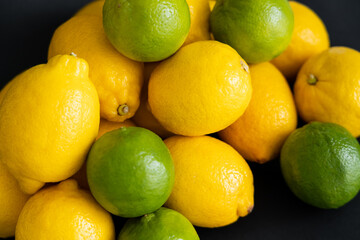 High angle view of organic lemons and limes on black background