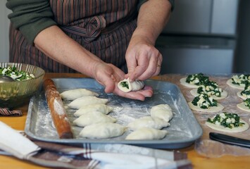 Senior woman prepares burgers. Grandmother cooks pies in the home kitchen. Homemade healthy food.