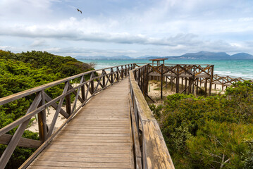 Majorca. Platja de Muro beach on a cloudy day. Wooden platform on the beach