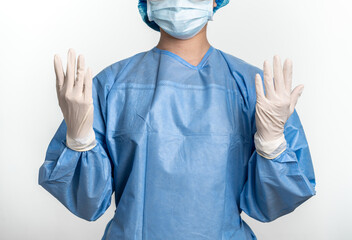 Female doctor or nurse with protective suit and mask is wearing medical gloves 