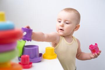 Cute kid girl playing in colorful plastic toys at home. Early childhood development