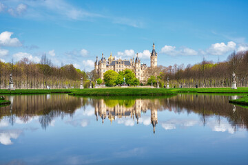 Schwerin castle, Schwerin palace in Germany. Schloss located in the capital of Mecklenburg-Vorpommern state, state parliament. View from the Schlossgarten, castle garden, with reflection in the water.