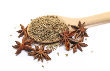 Anise seeds spice (Pimpinella anisum) in wooden spoon and star anise isolated on white