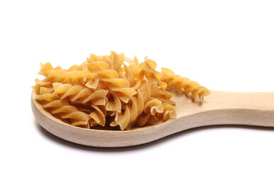 Pile wholemeal, integral pasta spirali in wooden spoon isolated  on white 