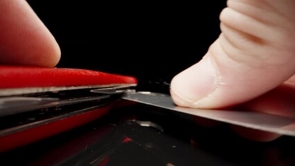 Red folding knife on black glass. I fold the blade .Dolly slider extreme close-up. Laowa Probe