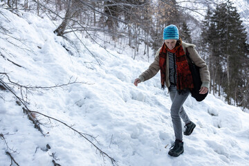 Fototapeta na wymiar Hiker carefully walking uphill on Icy Path
