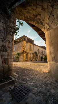 Large shot with arch of a small french village, south of france at Monpazier, near to the castles of Biron - in background the city hall