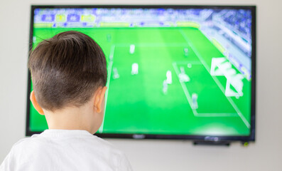 little boy and his father are playing a video game together, football match. football fan,idols, having fun together, family time.Father and son with gamepads playing video game, home interior.
