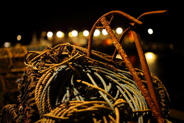 Lobster pots, rope and anchors on the quayside in Bridlington harbour, East Yorkshire, UK at night.