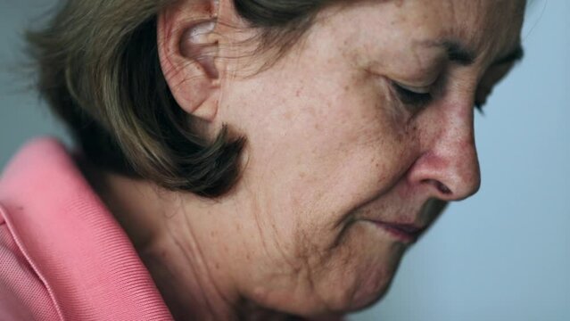 Pensive Older woman chewing food profile of senior person eating contemplative chews meal