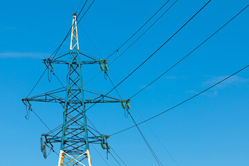 Background, view or scene of steel tower of electric main or electricity transmission line with the wires silhouette on background of clear blue sky