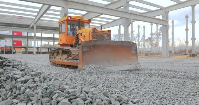 The bulldozer levels the layer of soil. Bulldozer works at a construction site. Yellow bulldozer at the construction site. Bulldozer at the construction site. Heavy construction equipment