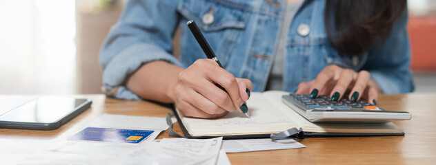 Woman doing accounting home finance expenses and calculate credit card monthly debt to bills payment.