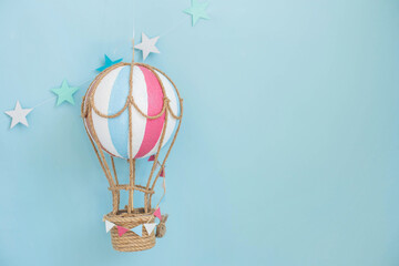 Hot air balloon toy in blue background and copy space. Hand made toys. Festive decor