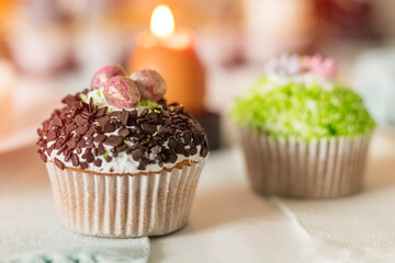 Easter cupcake with chocolate chips and eggs on the festive table. Gaussian Blurred Background
