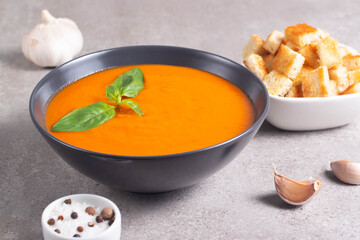 Fresh, healthy tomato soup with basil, pepper, garlic, tomatoes and bread on wooden background. Spanish gazpacho soup. Lentils and pumpkin soup.