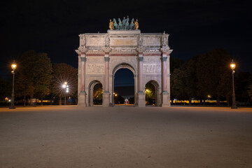 Arc de Triomphe du Carrousel is a triumphal arch in Paris, located in the Place du Carrousel, an example of Neoclassical architecture in the Corinthian order. At night. France. Louvre