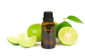 Lime essential oil in glass bottle and fresh lime fruits with green leaf isolated on white...