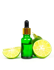 Lime essential oil in glass bottle and fresh lime fruits with green leaf isolated on white background. Use for spa, aromatherapy and body care concept.