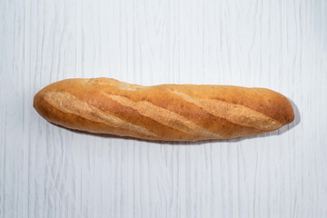 Loaf of bread baguette on white table breakfast food concept.