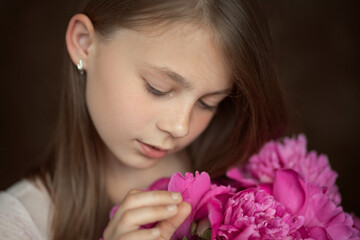portrait of a little girl with peonies in her hands